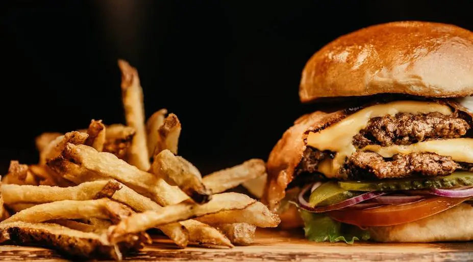 A hamburger and french fries on the table.